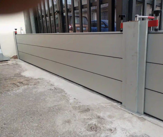 Une barrière anti-inondation de grande longueur devant l'entrée d'un garage