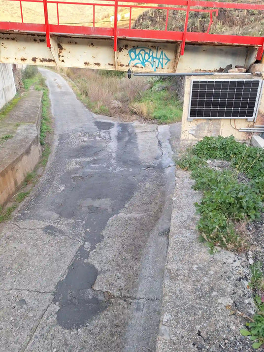 Station hydrométrique autonome installée sous un pont pour surveiller un cours d'eau