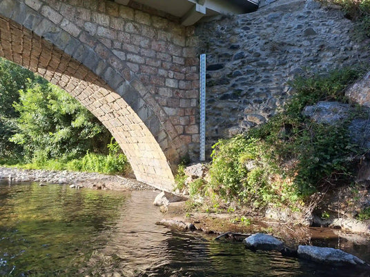 Échelle limnimétrique installée par OGOXE sur un ouvrage au bord d'un cours d'eau